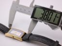 Digital caliper measuring the length of the Gucci watch case, displaying a precise measurement of 38.01 mm.