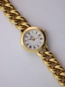 Close-up, slightly angled view of the Verity watch dial with black Roman numerals and gold-tone hands.
