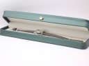 The Seiko 2205-0240-P watch with its grey leather strap resting inside a generic green leatherette display box.