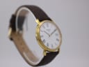 Another angled side view of the Tissot watch highlighting the slim gold case profile and lugs.