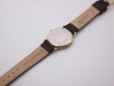 Back view of the Tissot watch showing the stainless steel case back engraving and the 'genuine leather' strap.