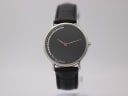 Front view of Michel Jordi G 900 watch with black dial and crystal accents on a stand.