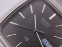 Close-up of the Seiko black dial, showing the quartz branding, SQ logo, and scratches on the crystal.