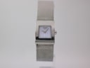 Front view of a Tissot L610K watch with a square stainless steel case and a light blue vertically textured dial on a mesh bracelet.