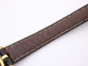 Close-up of the underside of the black leather strap, revealing significant wear, creasing, and discolouration on the brown lining.