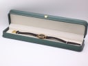 The Gucci 2000L watch with its black strap resting inside a generic green leatherette display box.