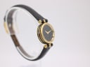Reverse angled side view of the Gucci 2000L watch, showing the elegant case profile and the black leather strap curving.