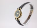 Angled side view of the Gucci 2000L watch, highlighting the unique ribbed gold and black case detailing and signed crown.