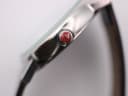 Macro shot of the red crown, signed with the Mondaine 'M' logo.