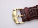 Close-up of the gold-tone Roamer signed buckle on the brown leather strap.