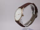 Angled side view of Bulova watch on a clear stand, showing the rose gold-tone bezel and crown, and silver-tone case sides.