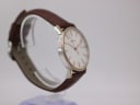 Other angled side view of Bulova watch on a clear stand, highlighting the slim profile and two-tone case.