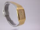 Another angled side view of the gold Seiko watch on a stand, highlighting the integrated bracelet design.