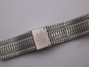 Close-up of the integrated bracelet's signed clasp, showing 'SEIKO BASE METAL TOP STAINLESS STEEL BACK JAPAN' engraving.
