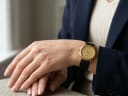 Watch modelled on a wrist, showing its size and elegant fit with a dark jacket.