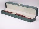 The Raymond Weil watch resting inside a generic green presentation box.