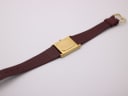 Back view of the Raymond Weil watch, showing the brushed gold-plated case back and strap.