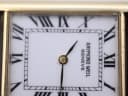 Extreme close-up of the Raymond Weil watch dial, showing minor marks on the white surface and crystal.