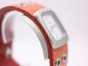 Angled side view of Nixon watch case and part of the brown leather cuff strap.
