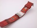 View of the underside of the Nixon watch strap and case back, showing some wear.