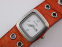 Close-up of the Nixon white dial with square case, showing hands and date window.