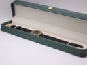 The Gucci watch presented inside a generic green leatherette display box.