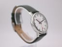 Side profile of the Mondaine watch on a display stand, highlighting the case and strap.