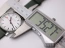Digital caliper measuring the Mondaine watch case diameter, displaying 35.27mm.