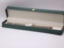 The Tissot watch carefully placed inside a generic green leatherette presentation box, a common studio prop for photography.