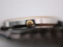 Macro shot focusing on the ribbed gold-tone crown, which is embossed with the Tissot 'T' emblem.