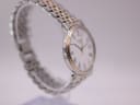 Side profile of the Tissot watch case and bracelet, showing the classic round design and polished finish.