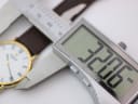Close-up of a digital caliper measuring the Raymond Weil watch case diameter at 32.06mm.