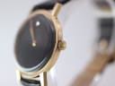 Side view of the watch case and winding crown, highlighting the gold-tone finish and slim profile.