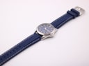 Top-down view of the Seiko watch laid flat, showing the full length of the navy rubber strap with white stitching and stainless steel buckle.