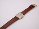 Overhead view of the entire Seiko watch and brown leather strap with buckle.