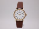 Front view of the Tissot T860K watch, showing its white dial with black Roman numerals and brown leather strap on a light background.