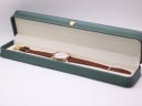 The Tissot watch presented inside a generic green leatherette display box, with the brown strap and gold-tone buckle visible.