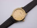 Close-up front view of the gold Tissot dial, 'TISSOT' logo, 'SWISS MADE' text, and baton markers.