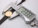 Digital caliper measuring the Tissot watch case, showing a diameter of 23.33mm.