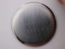 Close-up of the brushed stainless steel case back with "Yves Saint Laurent 51159 Quartz" engraving.
