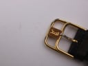 Close-up of the gold-tone buckle, clearly showing the engraved YSL logo.