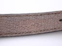 Close-up of the brown leather strap, showing the embossed "Yves Saint Laurent" text.