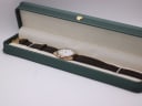 The Yves Saint Laurent watch displayed in a generic green leatherette presentation box.