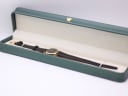 The Raymond Weil 9923 watch resting inside a generic green presentation box, a common studio prop.