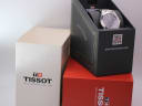 The original Tissot branded watch box, shown open with the watch inside, next to its outer packaging.