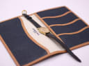 The Raymond Weil watch and strap laid inside a blue and tan watch roll/case.