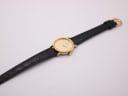 Overhead view of the entire Raymond Weil watch and black leather strap laid flat.