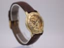 Angled left view of the gold Accurist skeleton watch, showing the crown detail.