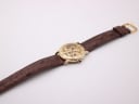 Top-down view of the full Accurist watch with its brown leather strap and gold-tone buckle.