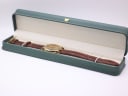 The Accurist watch displayed in a long, generic green leatherette presentation box with a gold crown emblem.